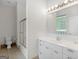 Bathroom showcasing a white vanity with a large mirror, bright lighting, and shower with glass doors at 95 Fern Ct, Stockbridge, GA 30281