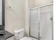 Well-lit bathroom featuring a toilet and a glass door shower with silver trim at 95 Fern Ct, Stockbridge, GA 30281