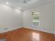 Light-filled bedroom showcases hardwood floors, white trim, and a large window at 95 Fern Ct, Stockbridge, GA 30281