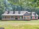 Charming brick home featuring a welcoming front porch and lush greenery, perfect for relaxation and curb appeal at 95 Fern Ct, Stockbridge, GA 30281