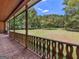 Inviting covered porch with brick flooring and decorative railing, offering picturesque views of the expansive yard at 95 Fern Ct, Stockbridge, GA 30281