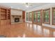 Cozy living room with a stone fireplace, built-in shelves, and large windows offering natural light and outdoor views at 95 Fern Ct, Stockbridge, GA 30281