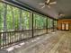 Covered porch features brick flooring, wood railing, ceiling fans and views of a wooded backyard at 95 Fern Ct, Stockbridge, GA 30281