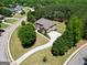 Aerial image of a traditional style home and large circular driveway surrounded by mature trees and landscaping at 105 New Castle Ln, Tyrone, GA 30290