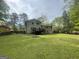 A spacious backyard with a deck, surrounded by mature trees and a wood fence at 780 Sweet Briar Se Trl, Conyers, GA 30094