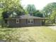 Cozy single-story home with a covered carport nestled among mature trees and a well-maintained lawn at 1391 Peachcrest Rd, Decatur, GA 30032
