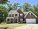 Charming two-story home with a brick facade, attached garage, manicured lawn and mature landscaping at 345 Manning Ct, South Fulton, GA 30349