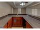 Basement wet bar with stained cabinets, laminate countertops, tile backsplash, and a stainless-steel sink at 135 Magnolia Dr, Oxford, GA 30054