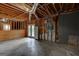 Unfinished basement with concrete flooring, exposed beams, and a door at 135 Magnolia Dr, Oxford, GA 30054