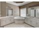 Bathroom with a large tub, double sinks, and white tile flooring to provide a luxurious experience at 135 Magnolia Dr, Oxford, GA 30054