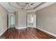 This bedroom has wooden floors, a ceiling fan, and two entryways, one leading to an ensuite bathroom at 135 Magnolia Dr, Oxford, GA 30054
