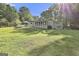 Expansive backyard features mature trees, lush lawn, screened-in porch, and patio area perfect for outdoor living at 180 Willow Lake Ln, Sharpsburg, GA 30277