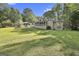 Expansive backyard features mature trees, lush lawn, screened-in porch, and patio area perfect for outdoor living at 180 Willow Lake Ln, Sharpsburg, GA 30277