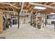 View of a large unfinished basement with concrete floor, exposed joists and ductwork, and ample storage space at 180 Willow Lake Ln, Sharpsburg, GA 30277