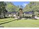 Charming single-story home with a stone chimney, mature trees, and a well-manicured lawn at 180 Willow Lake Ln, Sharpsburg, GA 30277
