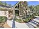 Close up of the front of this home featuring a stone chimney, modern windows, and landscaped beds at 180 Willow Lake Ln, Sharpsburg, GA 30277