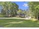 Beautiful front exterior view of home with a long circular driveway, well-maintained lawn, mature trees, and neutral tones at 180 Willow Lake Ln, Sharpsburg, GA 30277