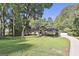 Beautiful front exterior view of home with a long circular driveway, well-maintained lawn, mature trees, and neutral tones at 180 Willow Lake Ln, Sharpsburg, GA 30277