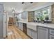 Well-lit kitchen boasts custom cabinets, stainless steel appliances, stone wall, and hardwood flooring at 180 Willow Lake Ln, Sharpsburg, GA 30277