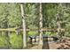 Picturesque pond with a wooden dock and chair surrounded by mature trees, perfect for relaxing outdoors at 180 Willow Lake Ln, Sharpsburg, GA 30277