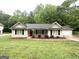 Inviting single-story home with neutral siding, black shutters, and a vibrant red front door at 221 Courthouse Park Dr, Temple, GA 30179