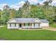 Charming single-story home featuring a well-manicured lawn, neutral siding, and a two-car garage at 221 Courthouse Park Dr, Temple, GA 30179