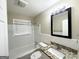 Bright bathroom features a tub, window, updated vanity with granite top and framed mirror at 1814 Mary Lou Se Ln, Atlanta, GA 30316