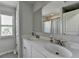 A light-filled bathroom with double sinks, white cabinets and modern fixtures at 7575 Old Camp Lndg, Cumming, GA 30040