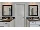 Bathroom featuring two vanities with dark countertops and matching mirrors at 7575 Old Camp Lndg, Cumming, GA 30040