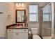 Neutral bathroom features framed mirror, functional storage, and glass enclosed shower at 7575 Old Camp Lndg, Cumming, GA 30040