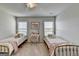 Bedroom featuring two twin beds with metallic frames, a vanity, and a ceiling fan at 7575 Old Camp Lndg, Cumming, GA 30040