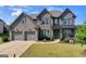 Stunning two-story brick home with a three-car garage and well-manicured lawn at 7575 Old Camp Lndg, Cumming, GA 30040