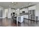 Bright kitchen features stainless steel appliances, island with barstool seating and hardwood floors at 7575 Old Camp Lndg, Cumming, GA 30040