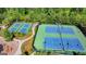 Aerial view shows well-maintained tennis courts with lush green landscaping and community signage at 7575 Old Camp Lndg, Cumming, GA 30040