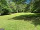 Lush green backyard with mature trees, providing a serene and private outdoor space at 3725 Concord Rd, Newborn, GA 30056