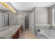 Bright bathroom featuring double vanity, granite counters, and soaking tub at 3725 Concord Rd, Newborn, GA 30056
