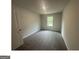 This bedroom has a neutral color palette, plush gray carpeting, and a window for natural light at 35 Emerald Ln # 14, Covington, GA 30014