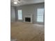 Living room features a decorative fireplace, neutral carpet and natural lighting at 871 Clearwater Rd, Sharpsburg, GA 30277