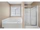 Well-lit bathroom featuring a soaking tub and a glass-enclosed shower at 2967 Albright Commons, Kennesaw, GA 30144