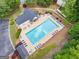 Aerial shot of the community pool area, surrounded by lounge chairs, tables, umbrellas, and lush landscaping at 2967 Albright Commons, Kennesaw, GA 30144