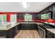Stylish kitchen with dark cabinets, granite countertops, stainless appliances, and bright red walls at 2967 Albright Commons, Kennesaw, GA 30144