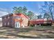 Home backyard with a brick exterior, patio seating, and natural landscaping at 5875 Highway 92, Fairburn, GA 30213