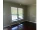 Living room with wood-look floors, neutral walls, and a window at 8145 Attleboro Dr, Jonesboro, GA 30238