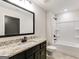 Modern bathroom features granite countertop, dark cabinets, and a shower-tub combo at 980 Temple Draketown Rd, Temple, GA 30179