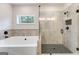 Bright bathroom featuring a tub and a glass-enclosed shower with tile accents and black fixtures at 980 Temple Draketown Rd, Temple, GA 30179