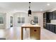 Bright kitchen with a large center island, dark cabinets, and open access to the dining and living areas at 980 Temple Draketown Rd, Temple, GA 30179