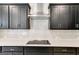 Close-up of kitchen details including backsplash, cooktop and stainless steel vent hood at 980 Temple Draketown Rd, Temple, GA 30179