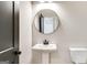 Contemporary powder room features a pedestal sink, matte black fixtures, and round mirror at 980 Temple Draketown Rd, Temple, GA 30179