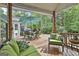 View of the back deck featuring ample seating, an umbrella-covered table, and a wooded view at 908 Huntington Pl, Peachtree City, GA 30269