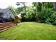 Well-manicured backyard with steps up to the back of the house at 908 Huntington Pl, Peachtree City, GA 30269